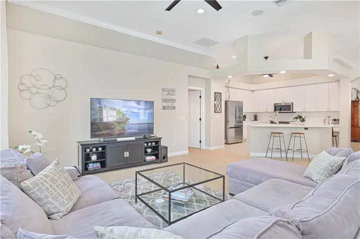 Living area featuring ceiling fan, crown molding, light tile patterned floors, and recessed lighting