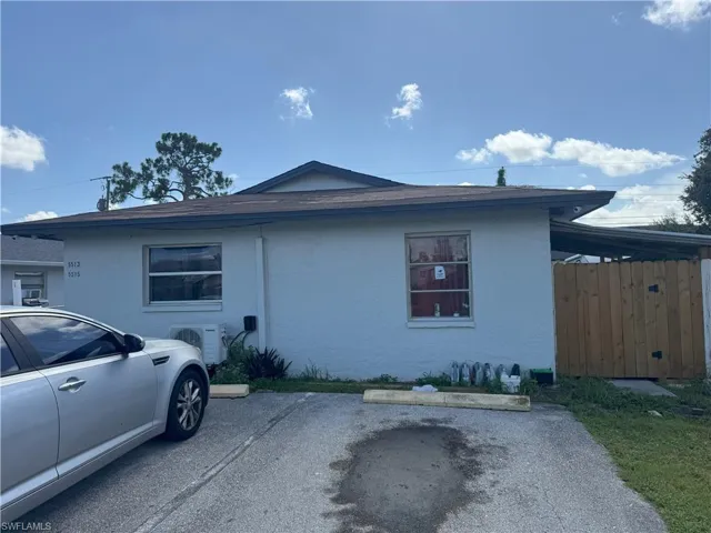 View of side of property with uncovered parking and stucco siding