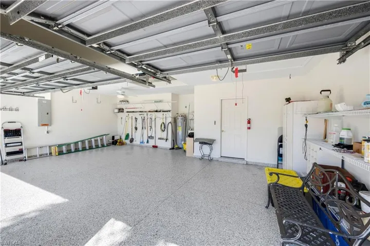 Garage featuring electric water heater and electric panel