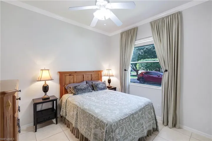 Bedroom featuring crown molding, ceiling fan, and light tile patterned floors