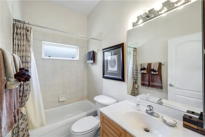 Guest Bathroom featuring vanity and shower / tub combo with curtain