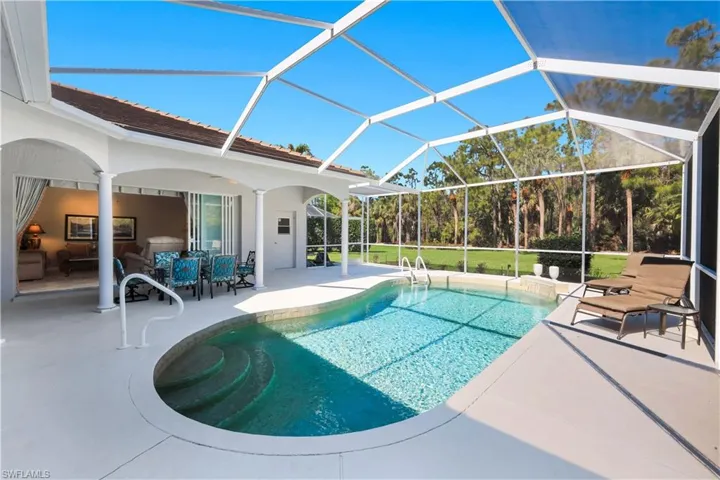 Outdoor pool with a patio, a lanai, a sunroom, and a lawn