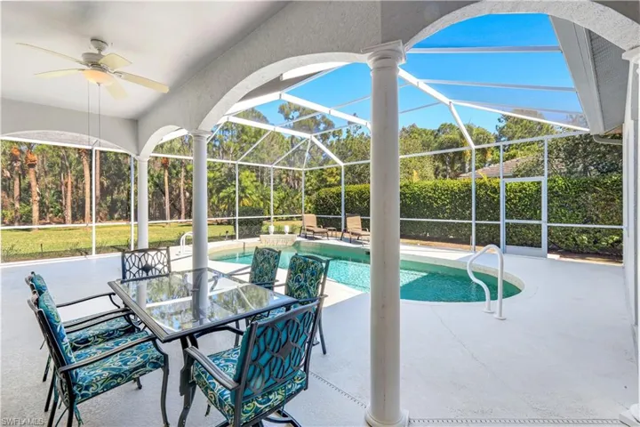 Outdoor pool featuring a sunroom, glass enclosure, a patio area, and outdoor dining space