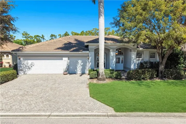 Ranch-style home with a front lawn, a garage, driveway, stucco siding, and covered porch