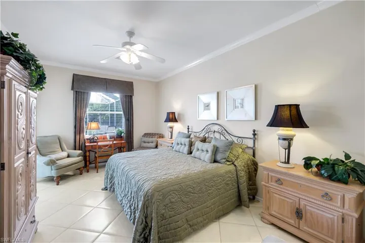 Master Bedroom with crown molding, light tile patterned flooring, and a ceiling fan