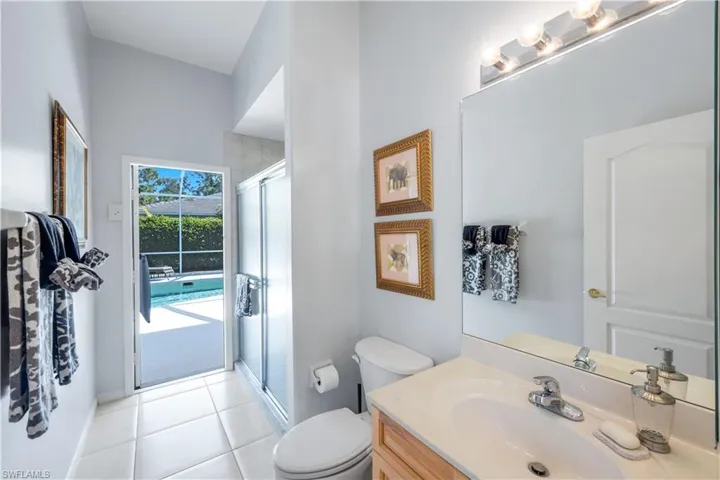 Guest & Pool bathroom with a stall shower, vanity, and light tile patterned floors