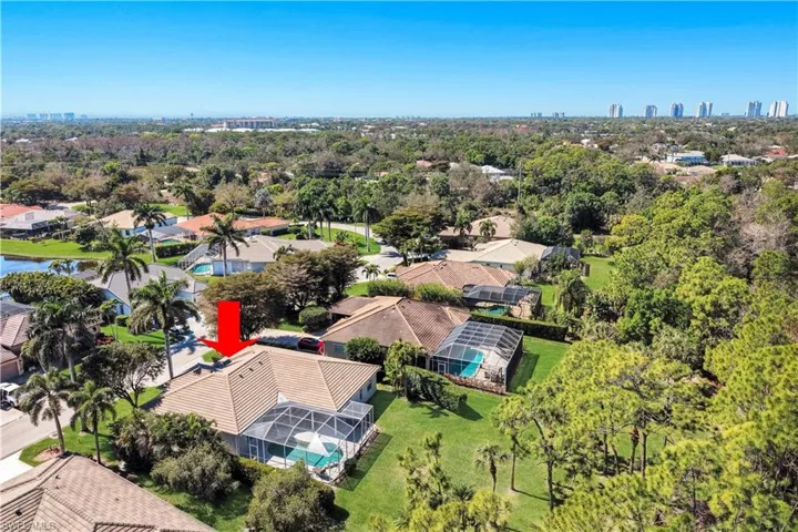 Aerial perspective of suburban area featuring city skyline and a tree filled landscape