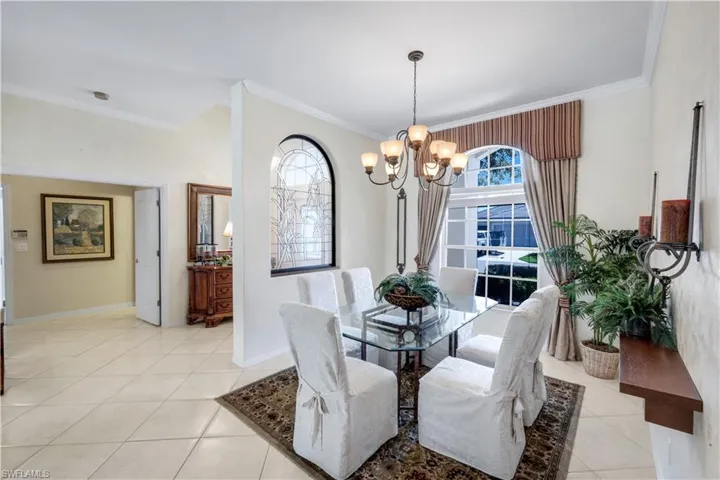 Dining room with suspended lighting, crown molding, and light tile patterned floors