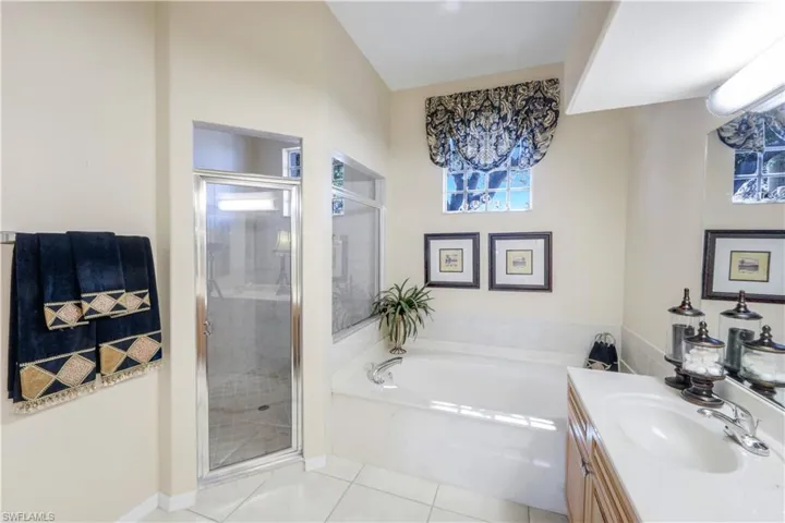 Master bathroom featuring vanity, a stall shower, a bath, and light tile patterned floors