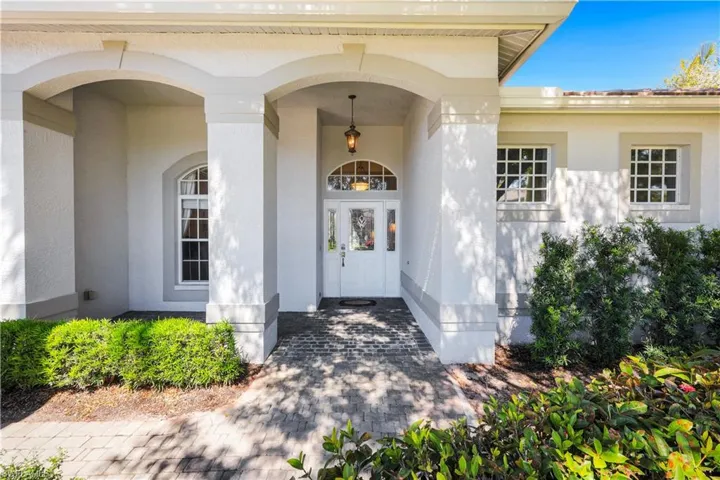 Doorway to property with stucco siding and covered porch