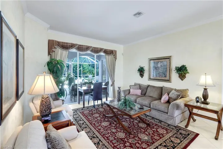 Living area featuring crown molding and light tile patterned floors