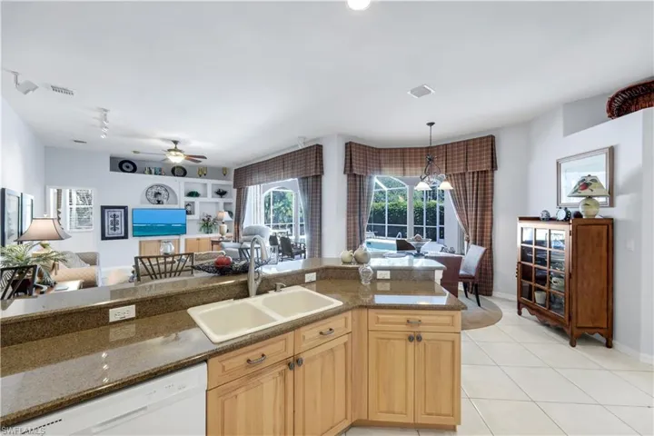Kitchen with open floor plan, dishwasher, a ceiling fan, and dark stone countertops