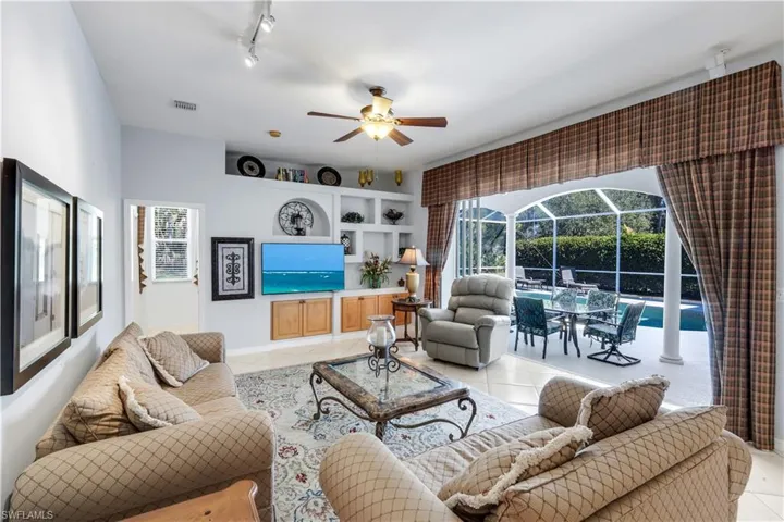 Living area featuring a sunroom, a ceiling fan, rail lighting, light tile patterned floors, and plenty of natural light
