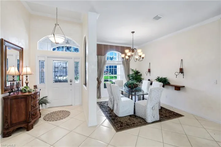 Entrance foyer featuring ornamental molding, a chandelier, and light tile patterned floors
