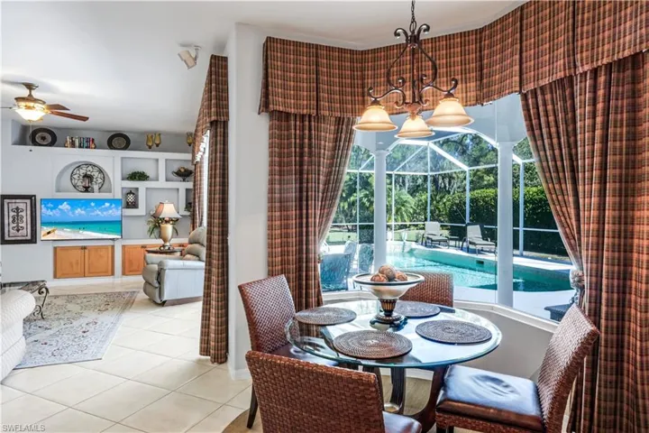 Tiled dining room with ceiling fan and a sunroom