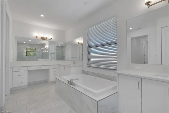 Primary bath with dual sinks and vanities.