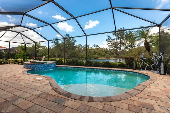 View of pool featuring a large lanai, in ground hot tub and a great view of the quiet lake and preserve.