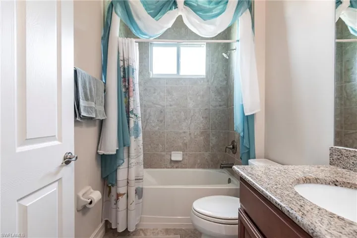 Full bathroom granite countertop, tile flooring and tub/shower combo.