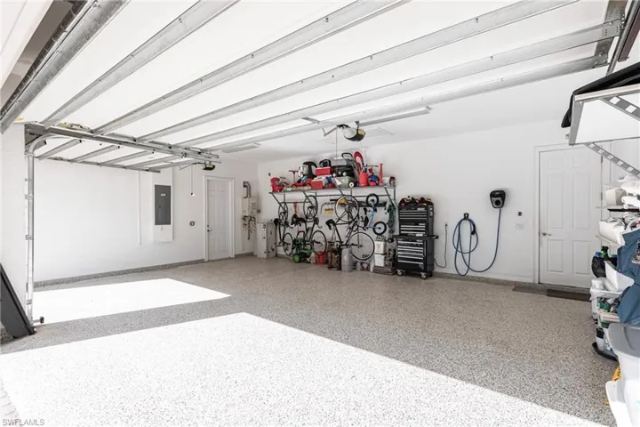 3 car Garage featuring epoxy flooring and storage shelving on walls.