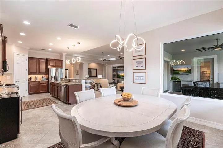 Tiled dining room with crown molding and decorative lighting.