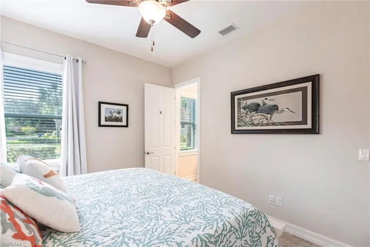 Bedroom featuring tiled floor, en-suite bathroom and plenty of natural sunlight.