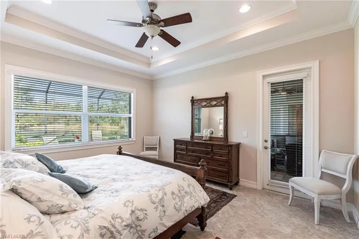 Master Bedroom with access to Lanai, a raised ceiling, ceiling fan, and crown molding