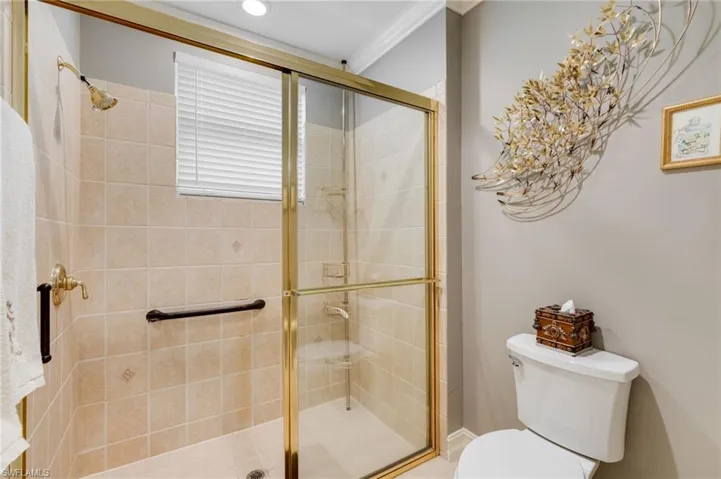 Full bath featuring a stall shower and ornamental molding