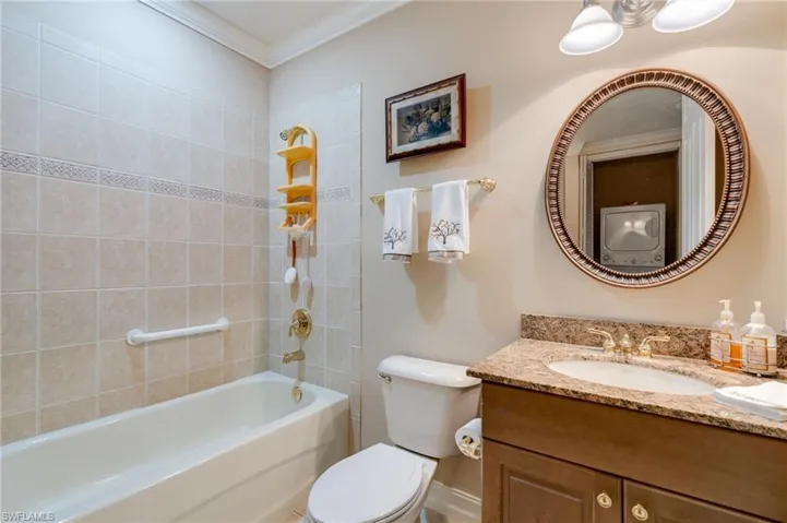 Bathroom featuring vanity, crown molding, and bathtub / shower combination