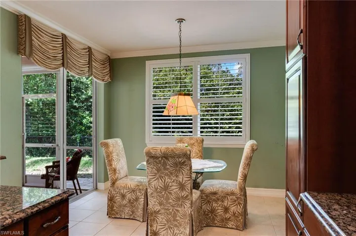 Dining room featuring crown molding and light tile patterned flooring