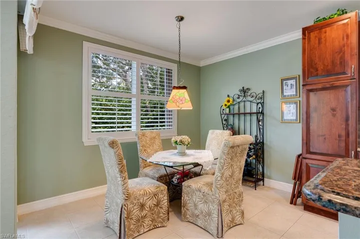 Dining space with ornamental molding and light tile patterned floors