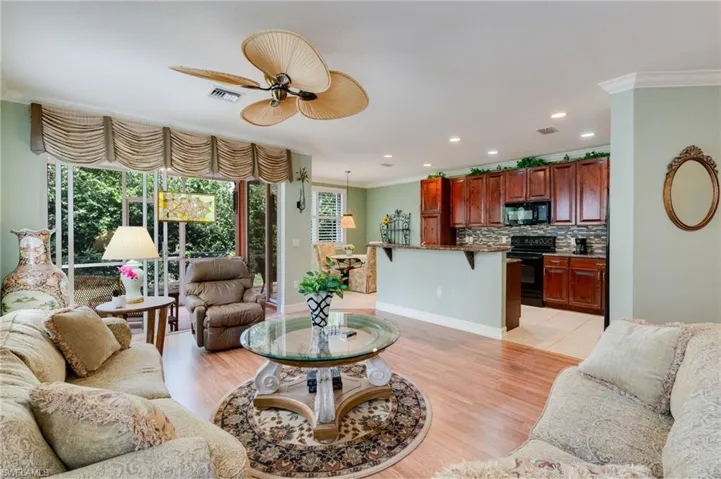 Living area featuring crown molding, ceiling fan, light wood-style floors, and recessed lighting