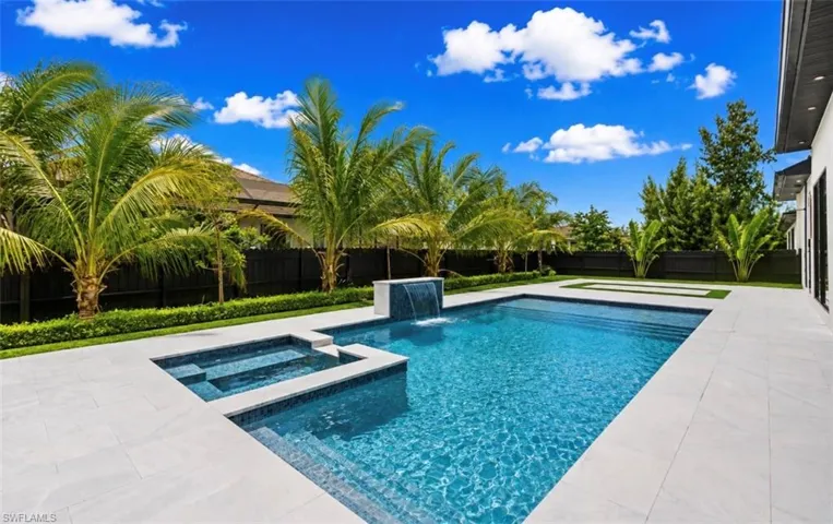 Rectangular swimming pool with integrated spa and waterfall feature