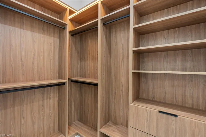 Wood-finish cabinetry featuring integrated lighting