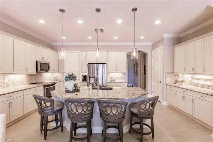 CABINETS & COUNTERTOPS GALORE WITH ONE-LEVEL GRANITE COUNTERTOP, WHITE CABINETS & UPDATED LIGHTING!