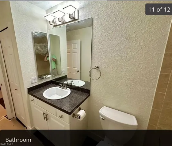 Bathroom with a textured wall and vanity