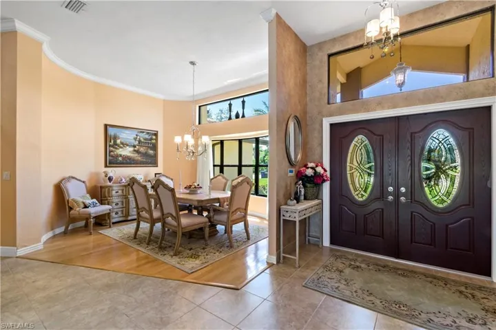 Entrance foyer with a notable chandelier, a high ceiling, hardwood / wood-style flooring, and ornamental molding