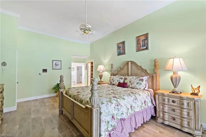 Bedroom with ceiling fan, ornamental molding, and hardwood / wood-style flooring