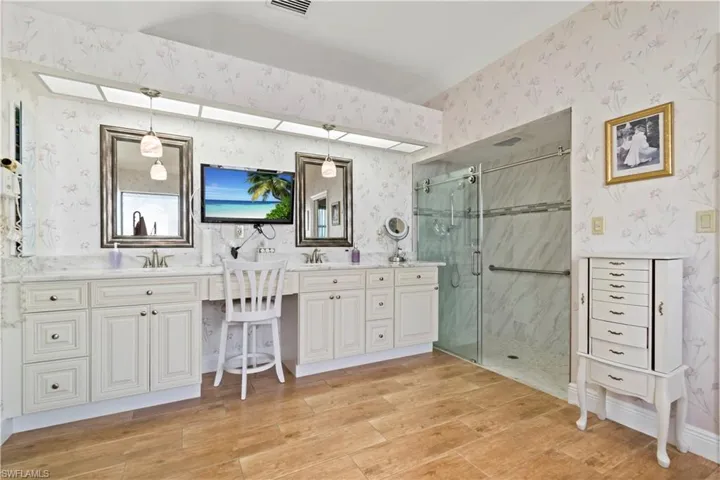 Bathroom with a shower with door and dual bowl vanity