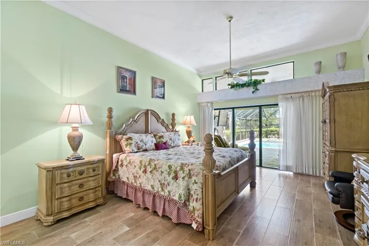 Bedroom with wood-type flooring, access to exterior, and crown molding