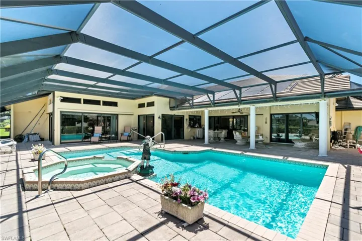 View of swimming pool with a patio area, a lanai, and an in ground hot tub