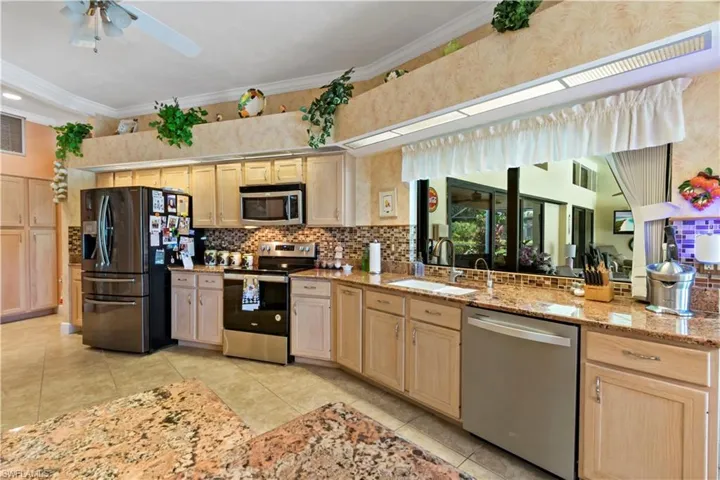 Kitchen featuring appliances with stainless steel finishes, sink, ceiling fan, and light brown cabinets