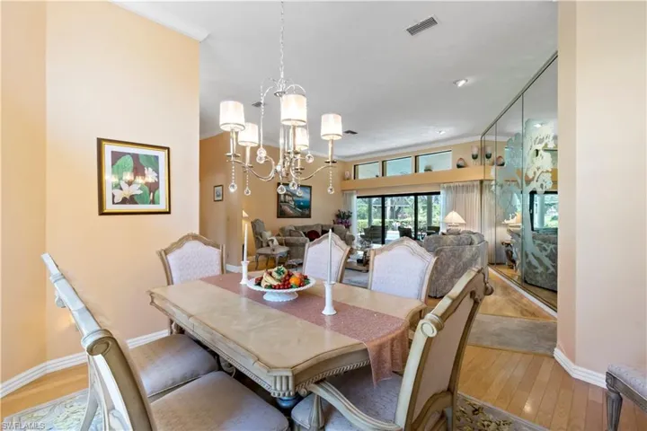 Dining space with ornamental molding, an inviting chandelier, and light hardwood / wood-style flooring