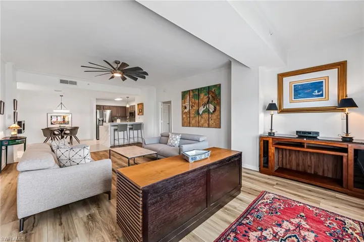 Living room with light hardwood / wood-style floors and ceiling fan