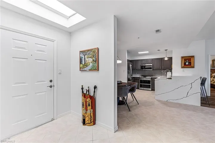 Entrance foyer with sink, a skylight, and light tile patterned floors