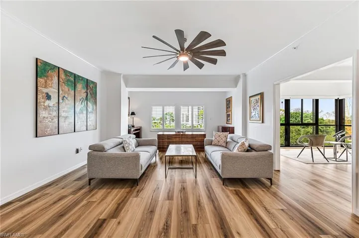 Living room featuring plenty of natural light, crown molding, ceiling fan, and hardwood / wood-style floors