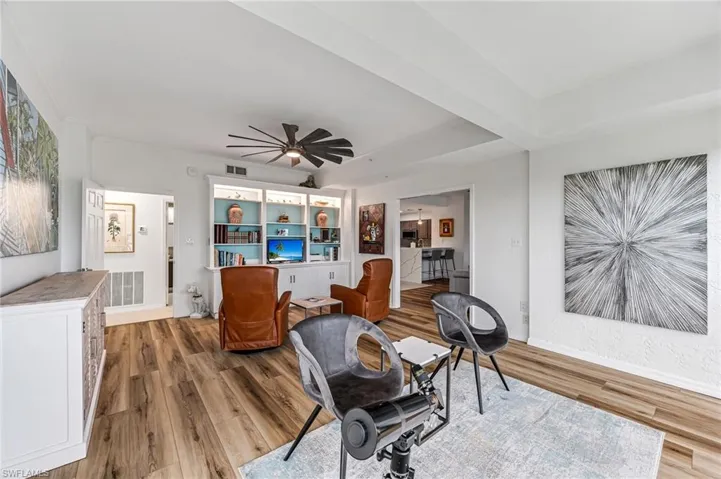 Den with ceiling fan and hardwood / wood-style floors