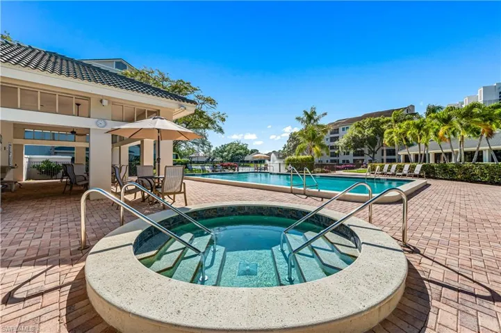 View of swimming pool with a patio area and a community hot tub