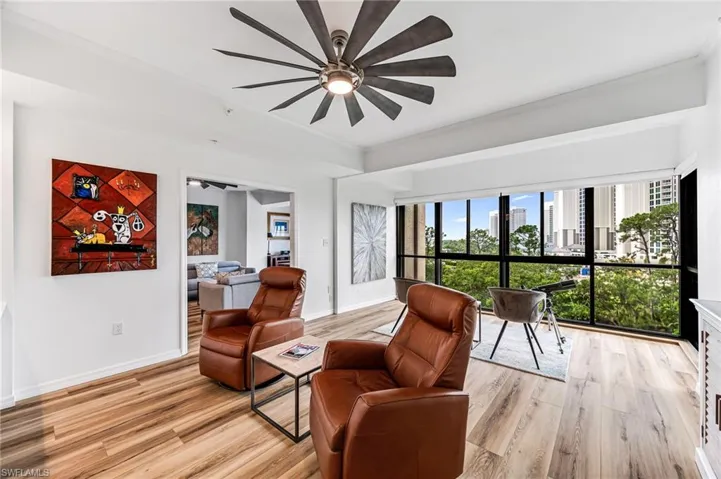 Den with crown molding, ceiling fan, and light hardwood / wood-style floors
