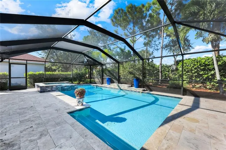 View of swimming pool with a pool with connected hot tub, a lanai, and a patio