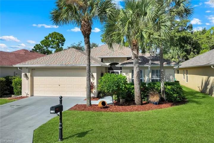 Lovely home featuring stucco siding, 2-car-garage, concrete driveway, and a front yard